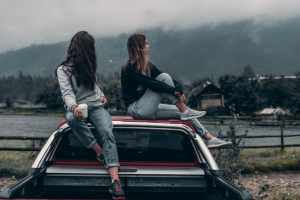 two girls on top of car